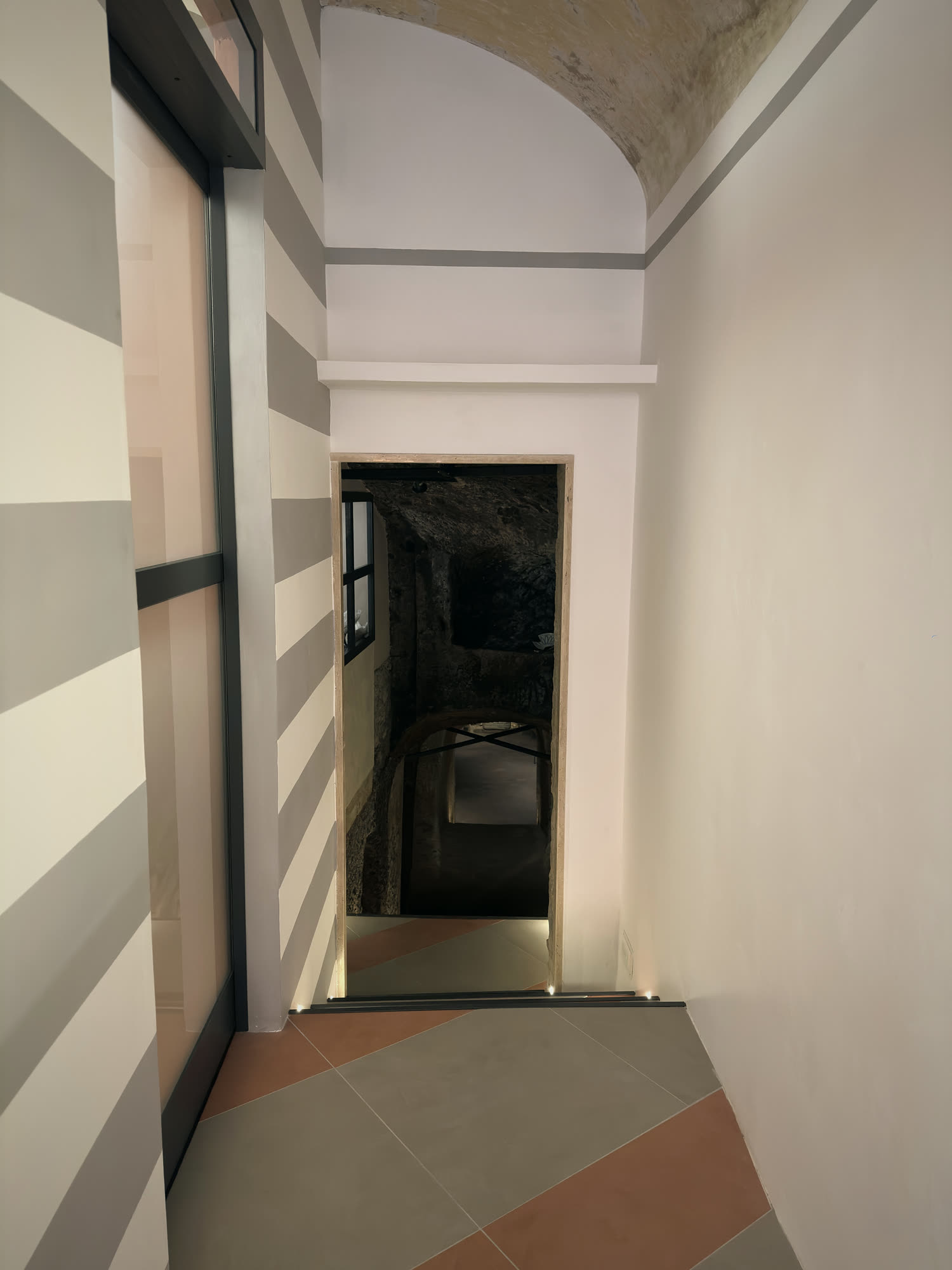 A striped corridor leading to the doorway into the tuff cellar.