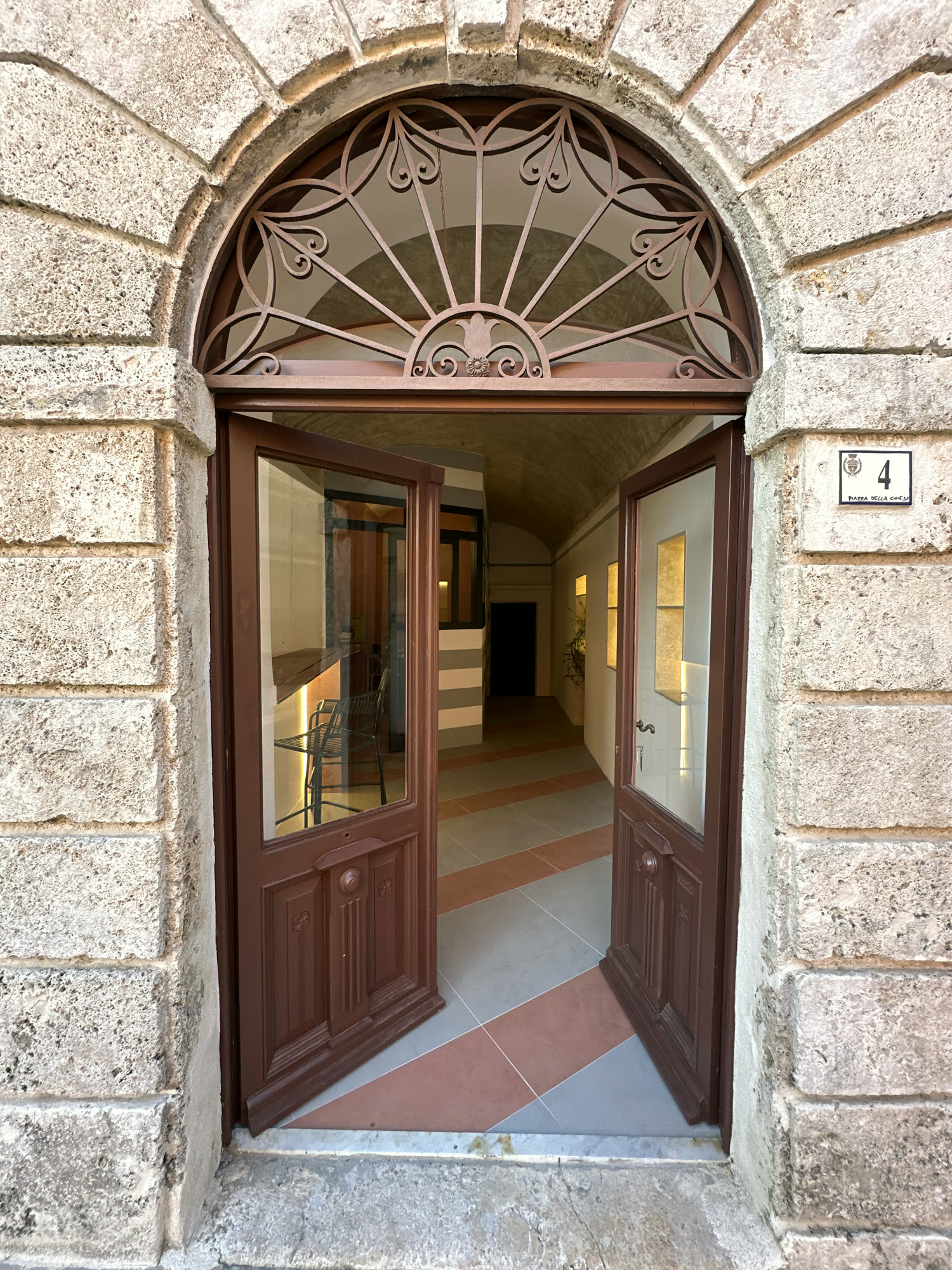 The arched doorway of the Locale della antica farmacia, open onto Piazza della Chiesa.