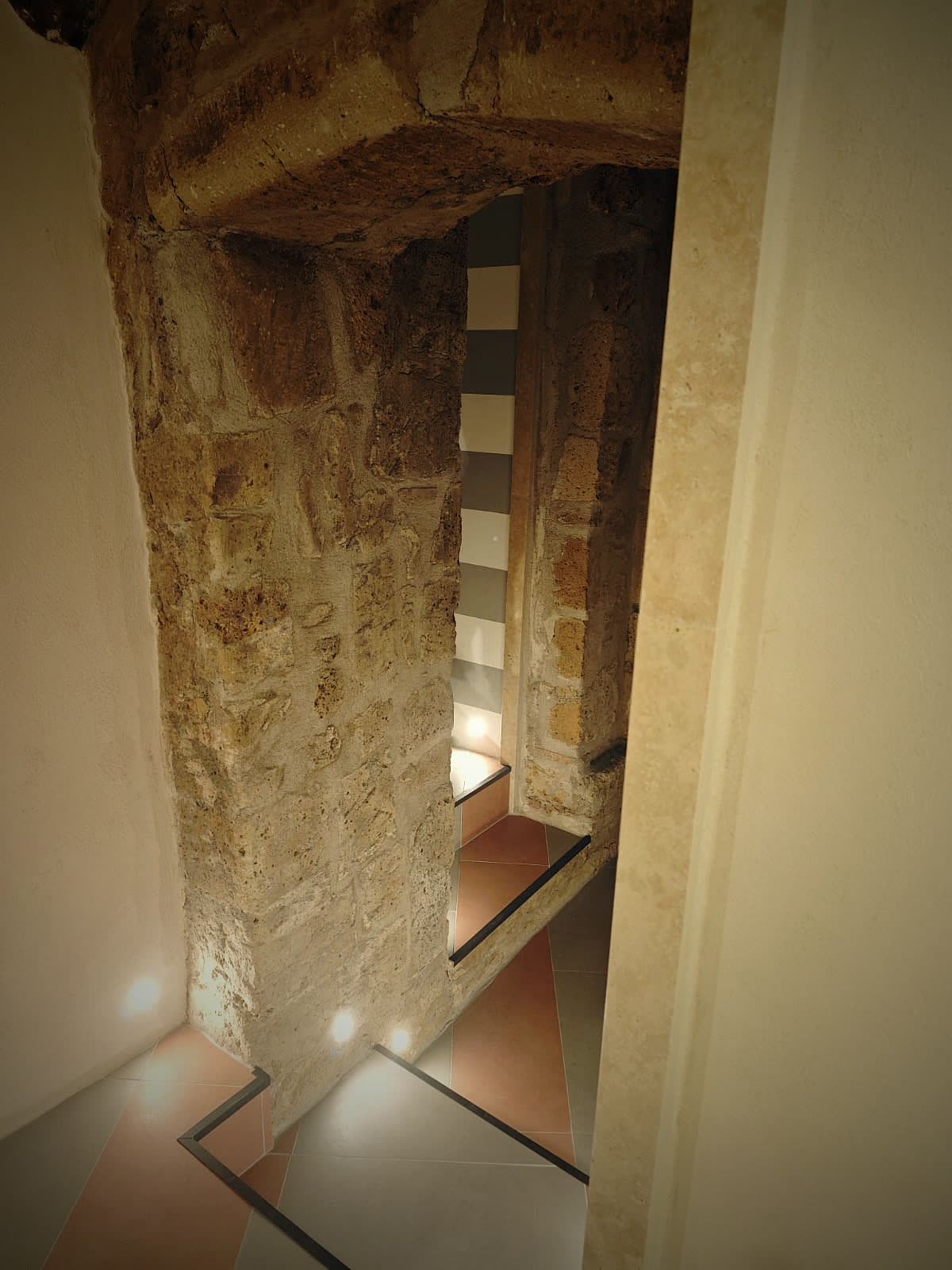 The illuminated tuff staircase descending into the cellar.