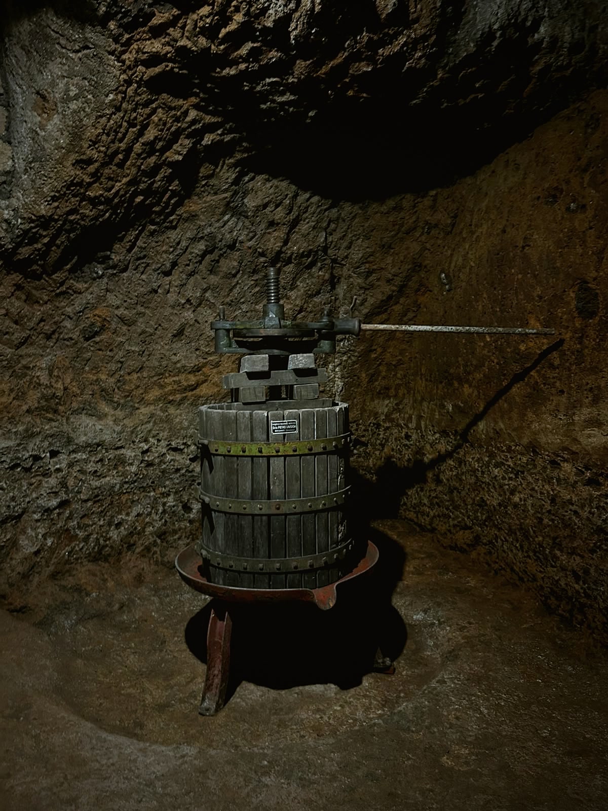 An antique wooden wine press standing in the tuff cellar.